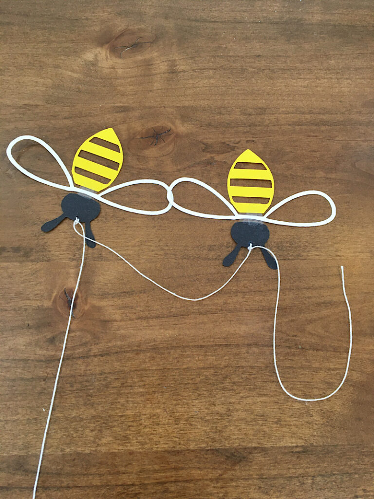 knotting the bees onto the garland string