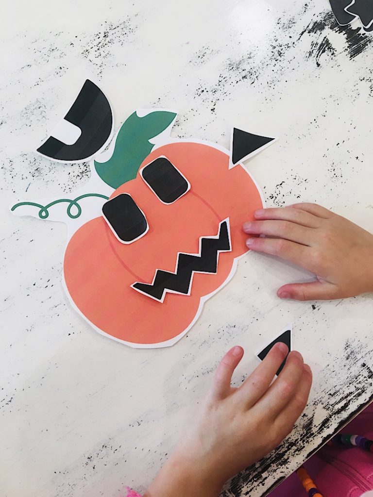 Jack o lantern cut and glue printable on table with hands